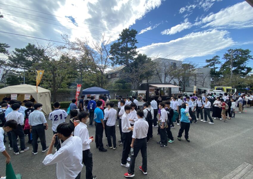 お昼時、体育館横のスペースが大賑わい。逗子商店街の方々の協力でいろんなおいしいものが食べられます。